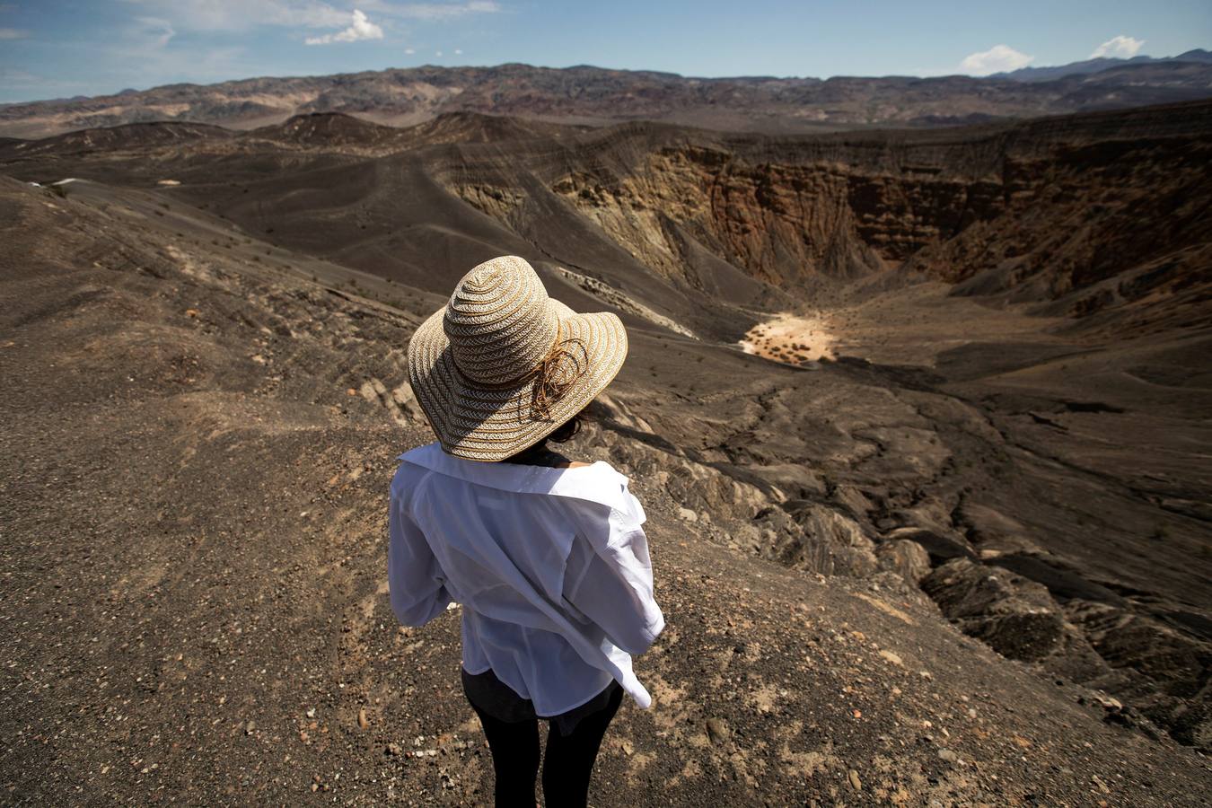Una turista camina alrededor del borde del cráter Ubehebe, en el Valle de la Muerte