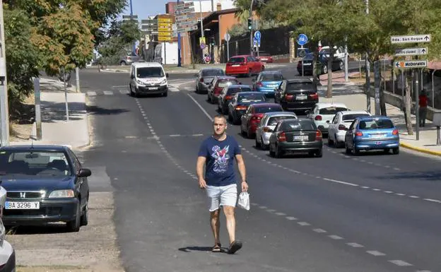 Un vecino camina por la cuneta en la carretera de la Corte mientras los coches pasan a su lado.: 