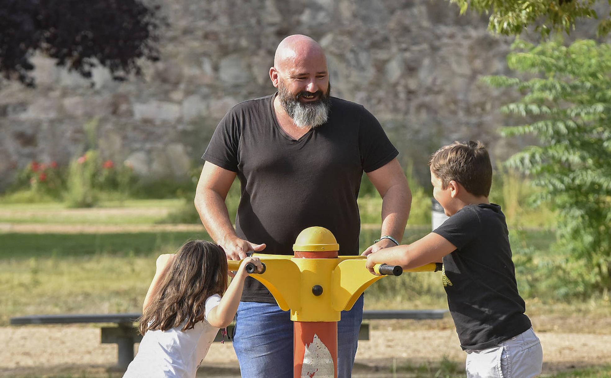 Carlos García juega con sus hijos en un parque de Badajoz durante el último día de sus vacaciones con ellos . :: C. MORENO 