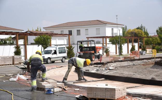 Operarios trabajan en la construcción de la nueva plaza que se levanta en Saucedilla, localidad en la que hay más de seis obras en marcha estos días.: DAVID PALMA