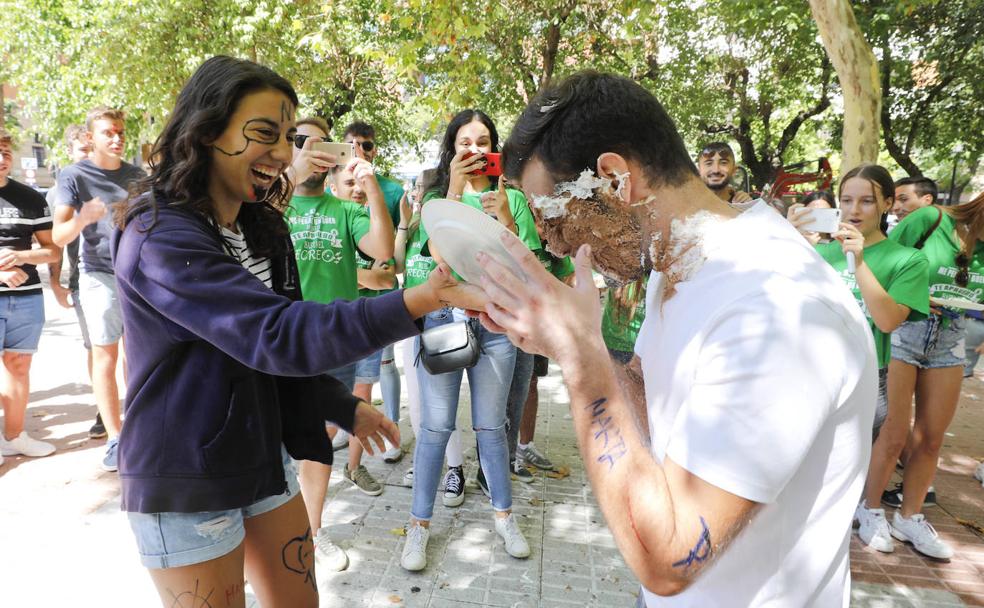 Un estudiante recibe un 'tartazo' en la cara de manos de una compañera, ayer en Cánovas.: 