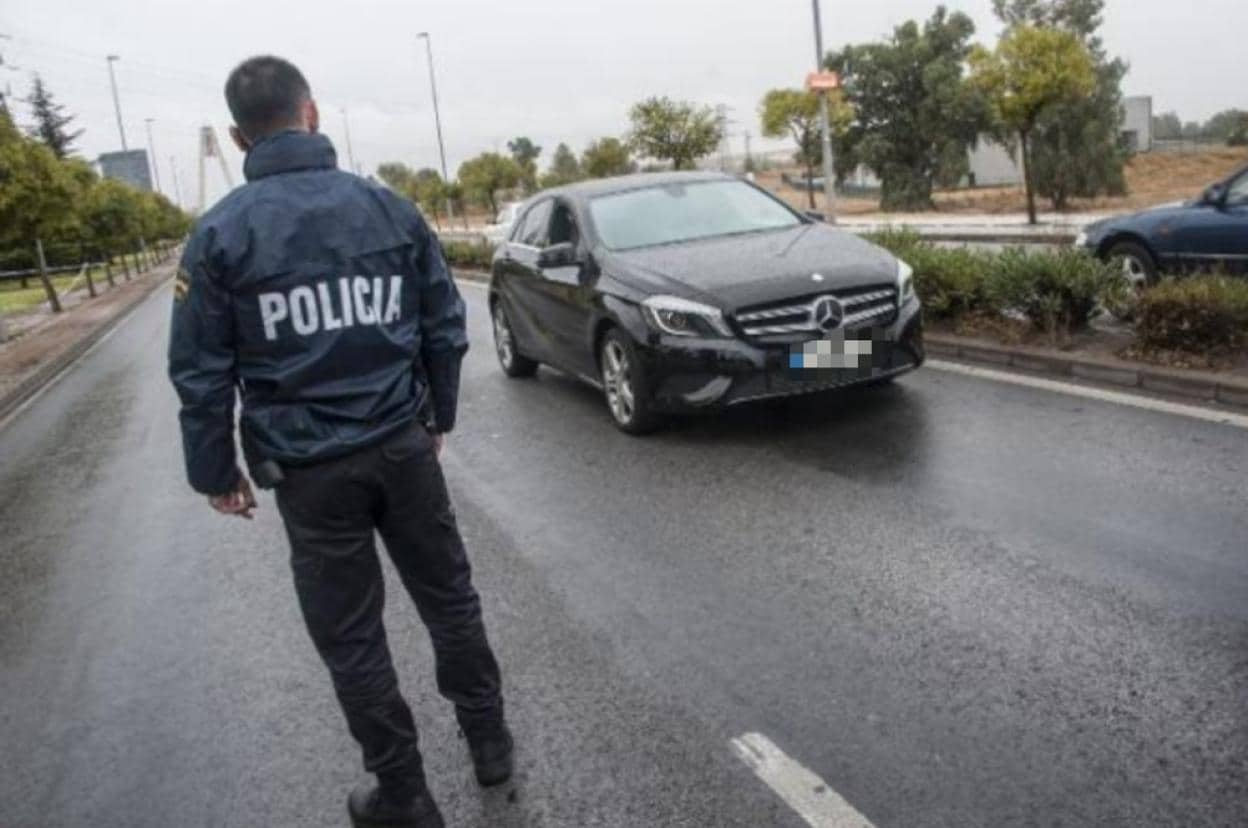 Un agente de la Policía Nacional observa un vehículo que fue tiroteado en Badajoz el pasado día 21. :: hoy