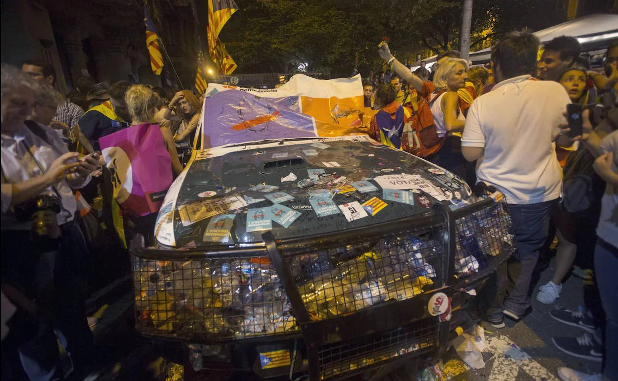 Coche patrulla de la Guardia Civil destrozado a la puerta de la Consejería de Economía de la Generalitat, el 20 de septiembre de 2017, tras el asedio al que fue sometida por partidarios del referéndum. 