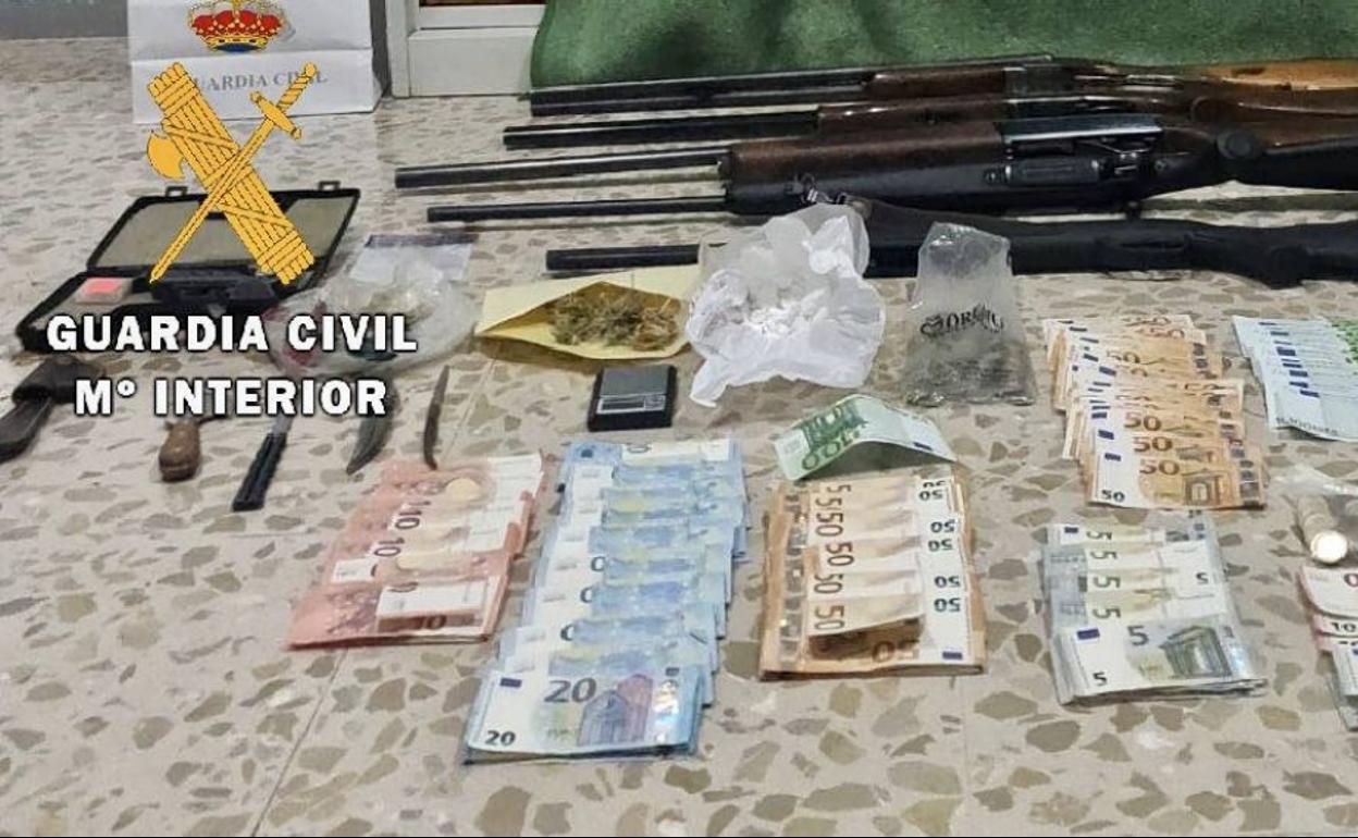 Armas, dinero y droga incautada en un registro a uno de los domicilios. 