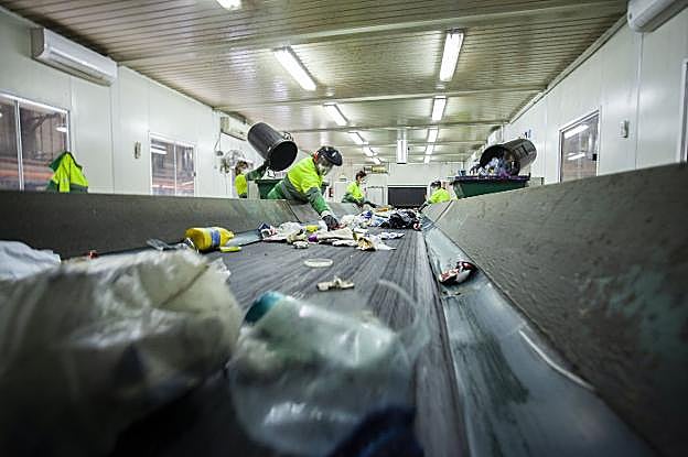 Cinta de tratamiento manual de los residuos domésticos con operarios trabajando en el ecoparque de Cáceres. :: jorge rey
