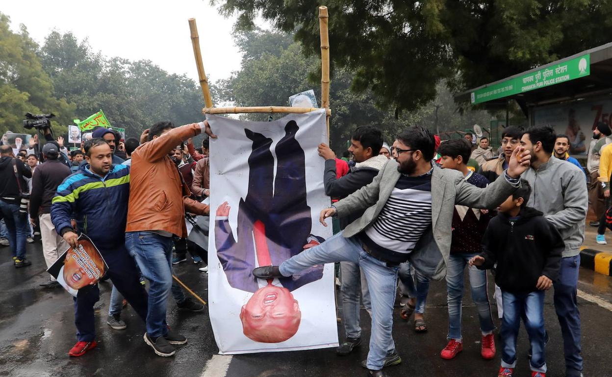 Musulmanes indios patean un póster con la imagen de Donald Trump durante una protesta por el asesinato de Suleimani en Delhi.