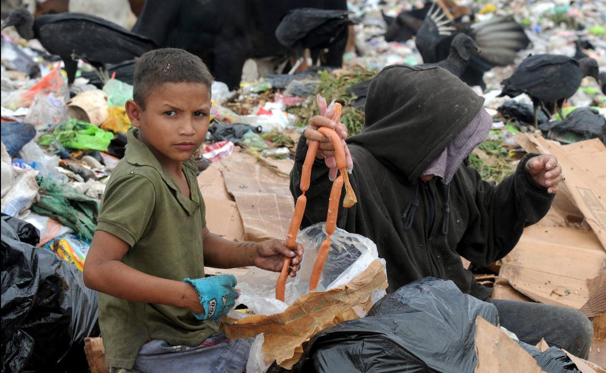 Una madre y su hijo buscan comida entre la basura en Honduras.