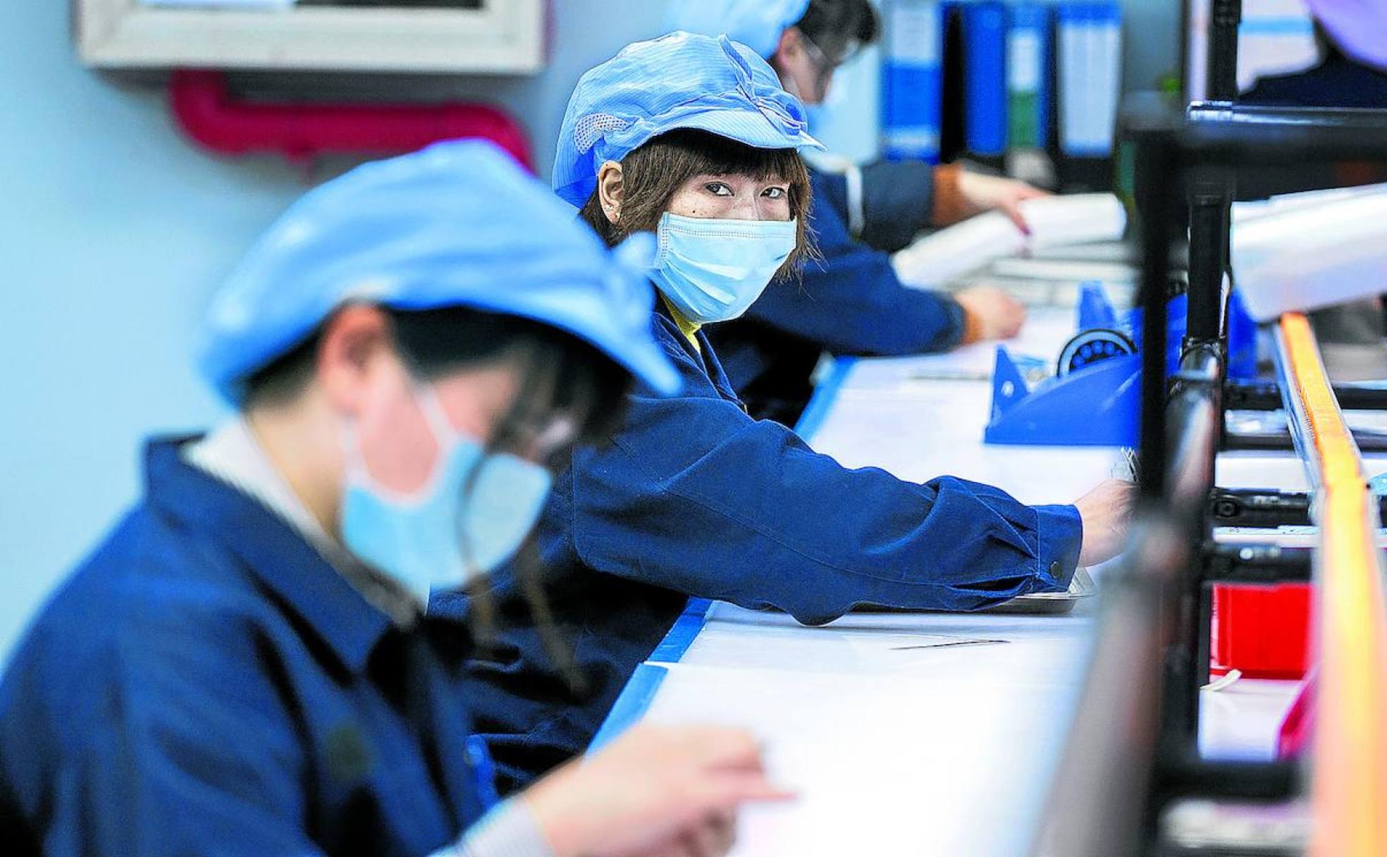 Todos los operarios de las fábricas chinas trabajan con las mascarillas puestas.