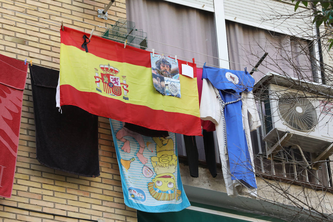 Los barrios como Nueva Ciudad sacan los colores y túnicas de nazarenos a los balcones