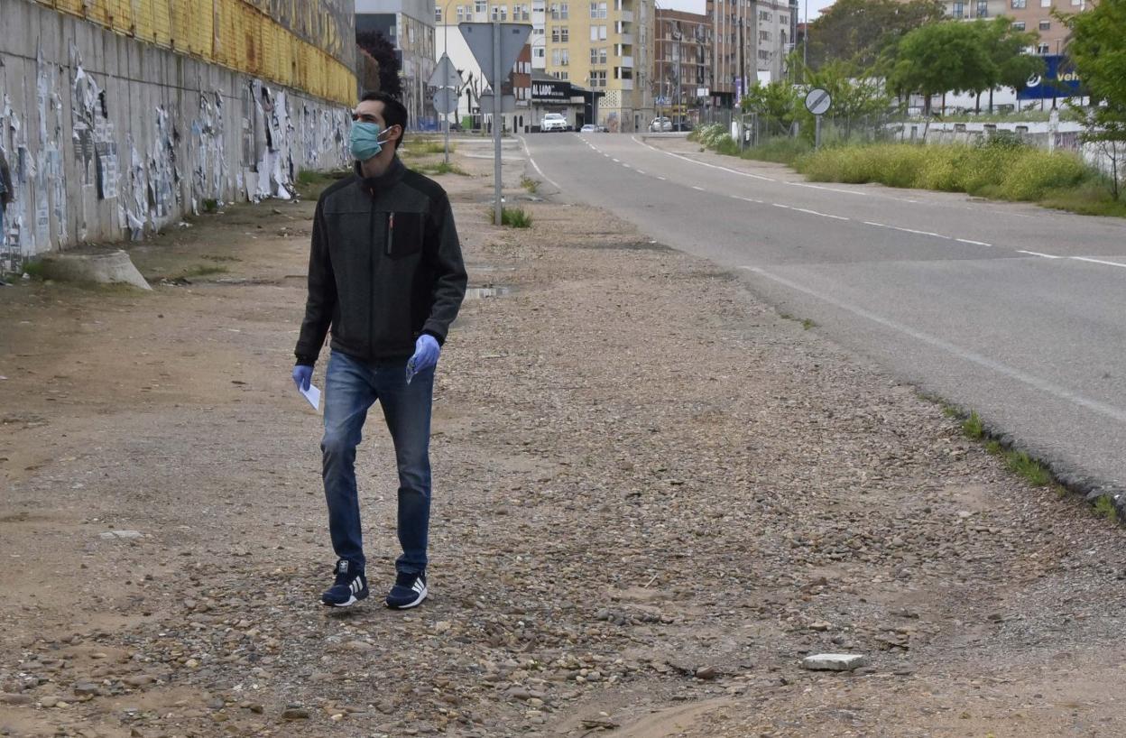 Un peatón camina por la tierra debido a la falta de acera en Ricardo Carapeto. 