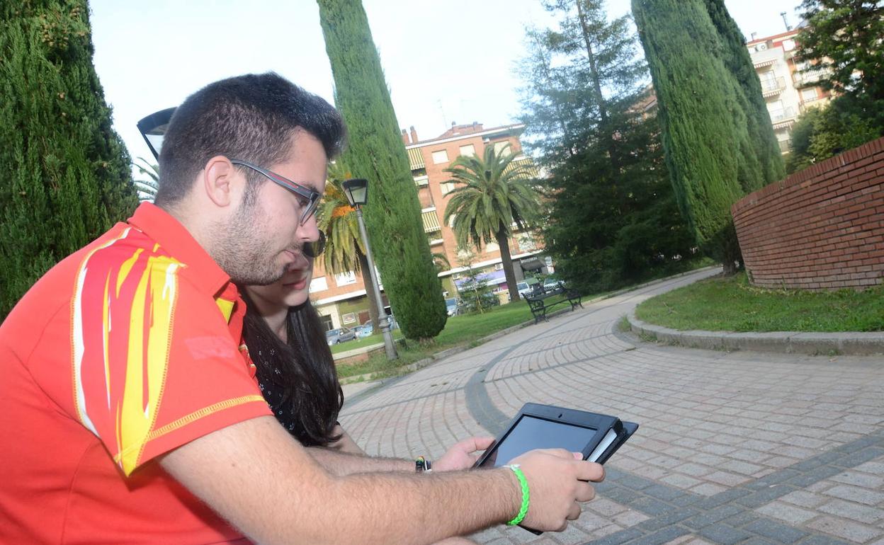 Un joven maneja una tablet en un parque en una imagen de archivo. 