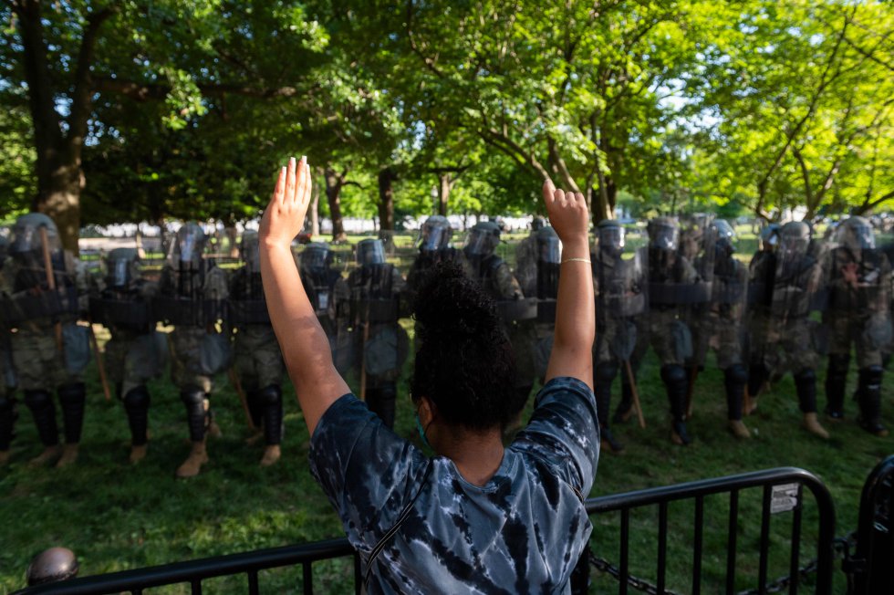 Una manifestante levanta los brazos frente a la Guardia Nacional a las afueras de la Casa Blanca