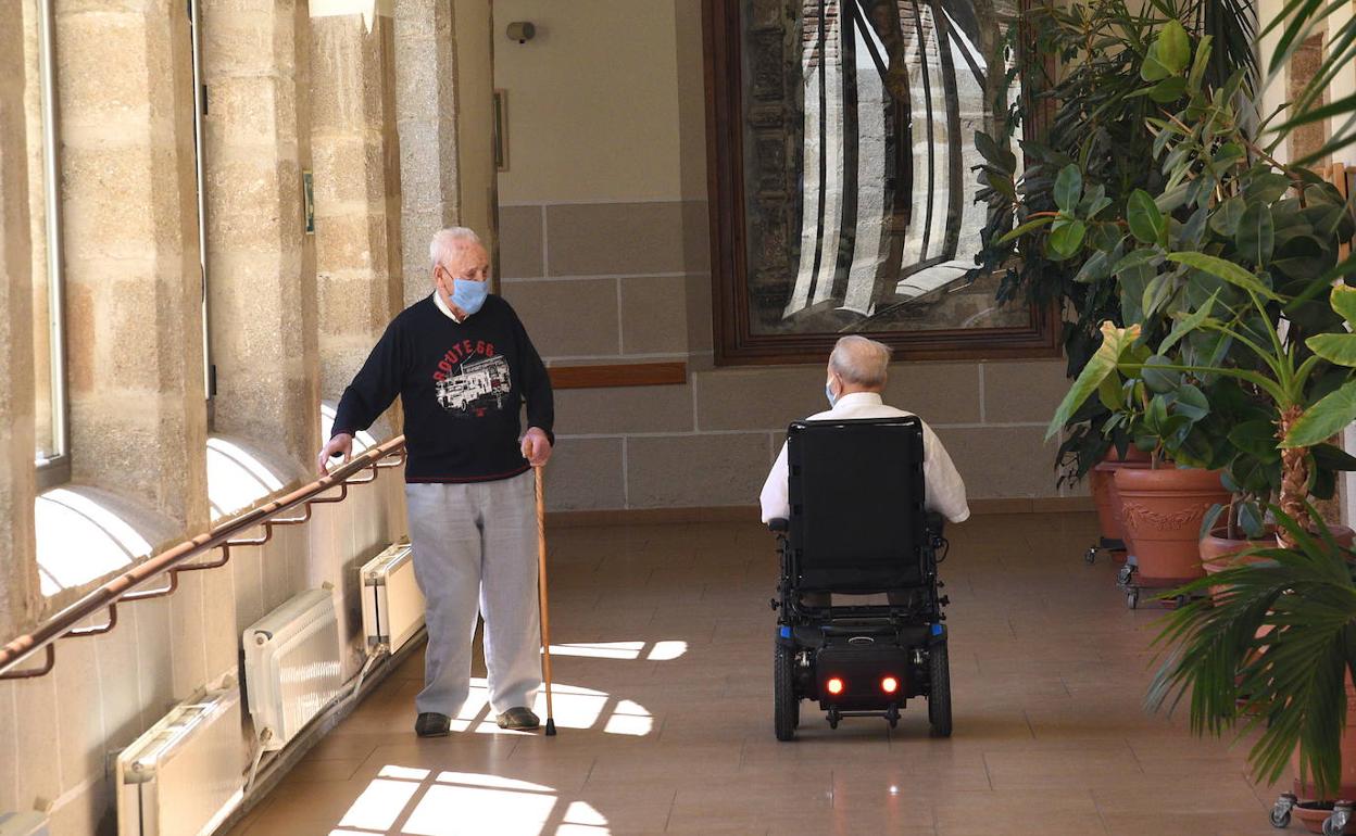 Dos mayores mantienen la distancia de seguridad en una residencia de Plasencia. 