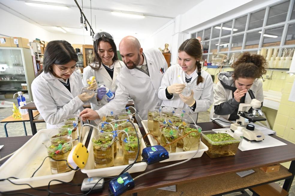Las alumnas y el profesor Del Moral de los Maristas haciendo su experimento contra el camalote. 