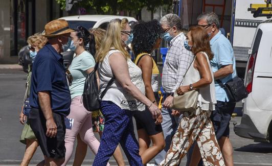 Pacenses andando ayer con mascarillas.