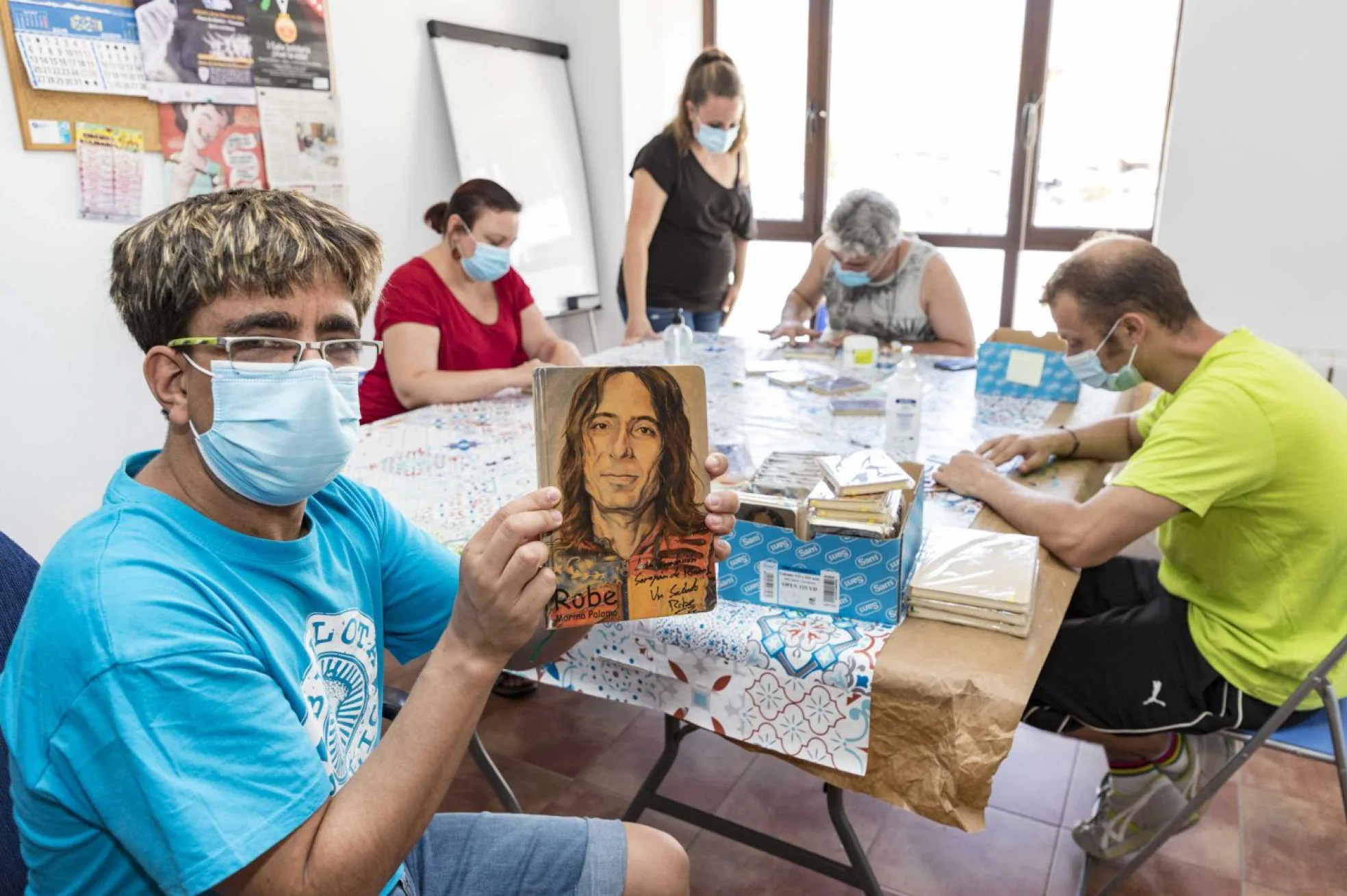 Marina Palomo con usuarios del centro de empleo elaborando las libretas de Robe. 