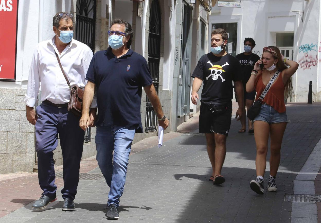 Gente con y sin mascarillas por las calles. 