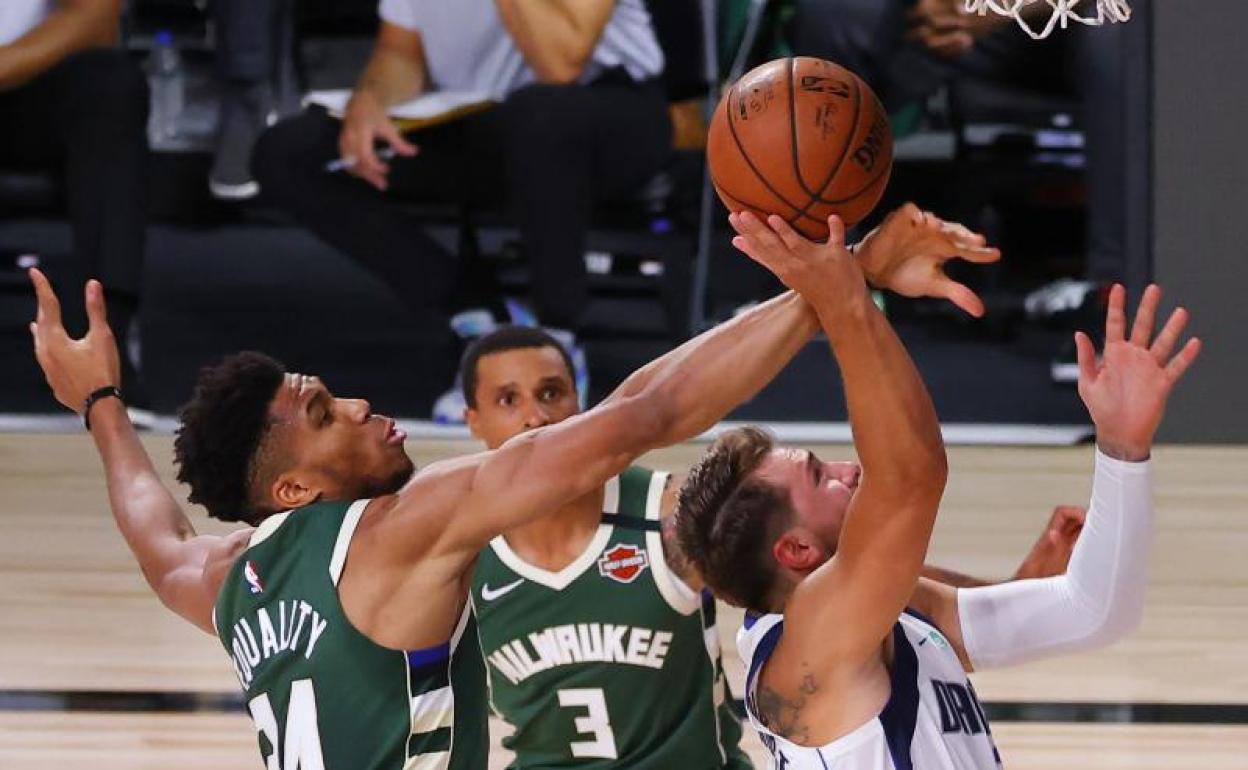 Antetokounmpo trata de obstaculizar un lanzamiento de Doncic. 