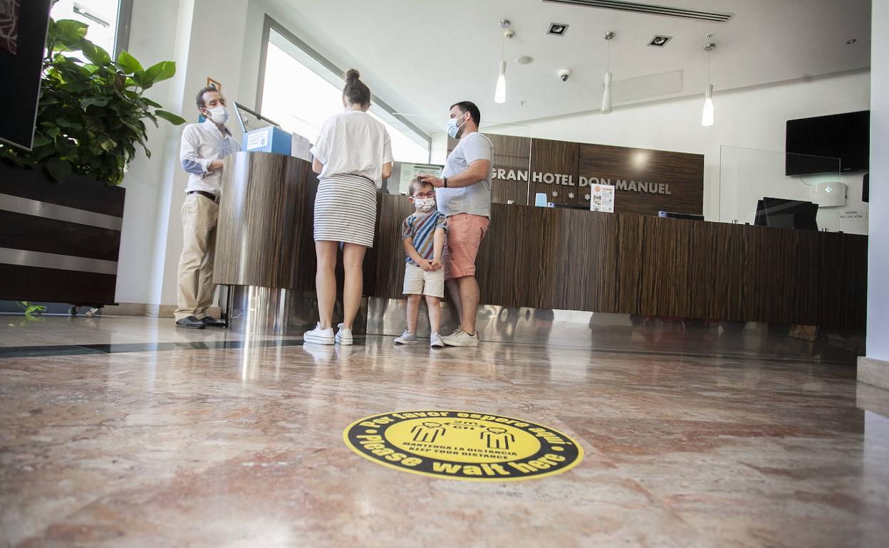 Turistas en la recepción del hotel DonManuel, de Cáceres; estos establecimientos están teniendo una ocupación cercana al 35% en agosto. 