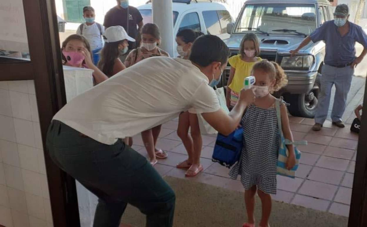 Toma de temperatura de niños a la entrada de una instalación.