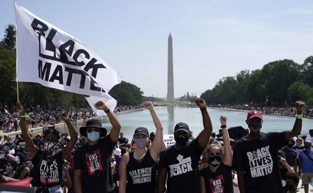 Activistas del movimiento 'Black Lives Matter' levantan sus puños durante la marcha celebrada este viernes en el National Mall, en Washington.