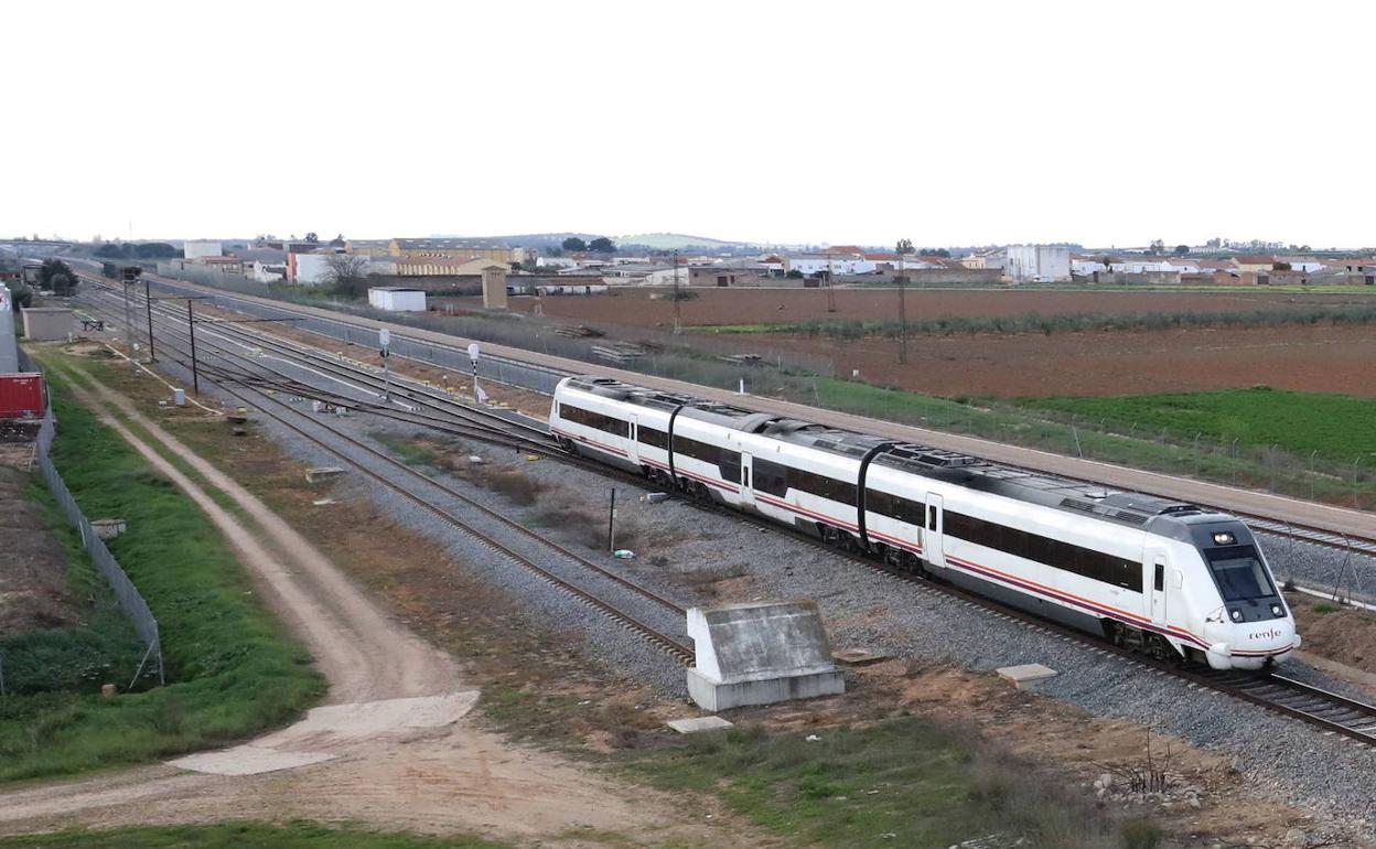 Un tren convencional circula junto a la vía del AVE entre Mérida y Badajoz 