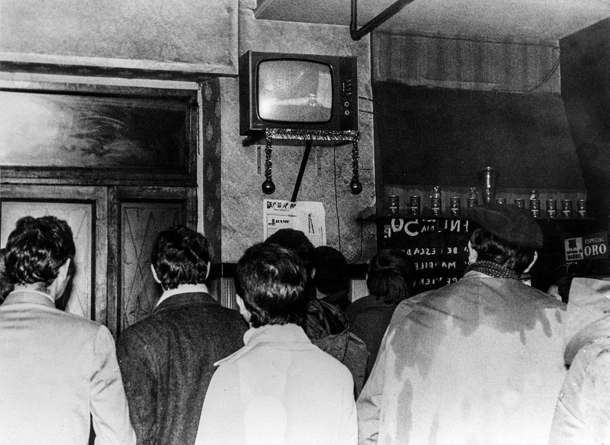 Un grupo de personas escucha en un bar de Burgos la noticia de que el Jefe de Estado, Francisco Franco, ha conmutado las nueve penas de muerte. 