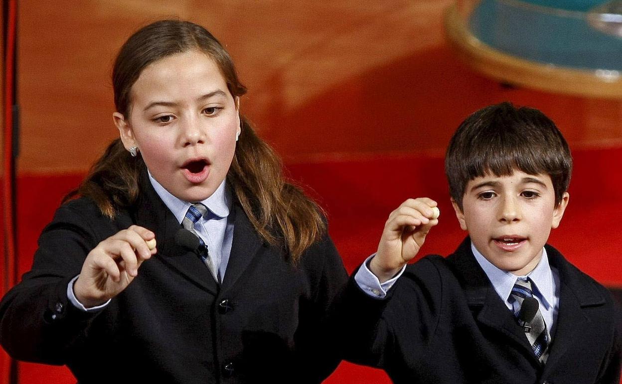 Dos niños de San Ildefonso cantan un premio. 