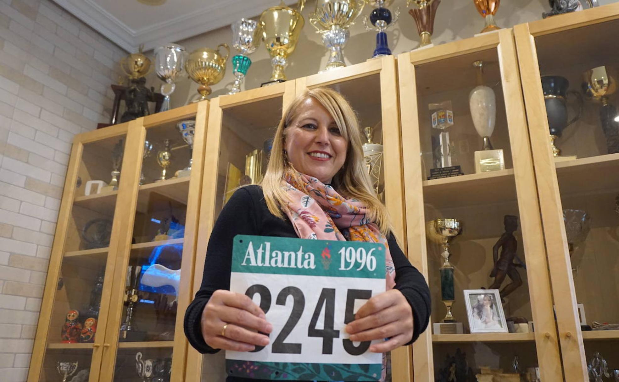 Marisa Martínez posa con el dorsal de Atlanta 1996 delante una parte de los trofeos que tiene en su casa de Valdelcalzada. 