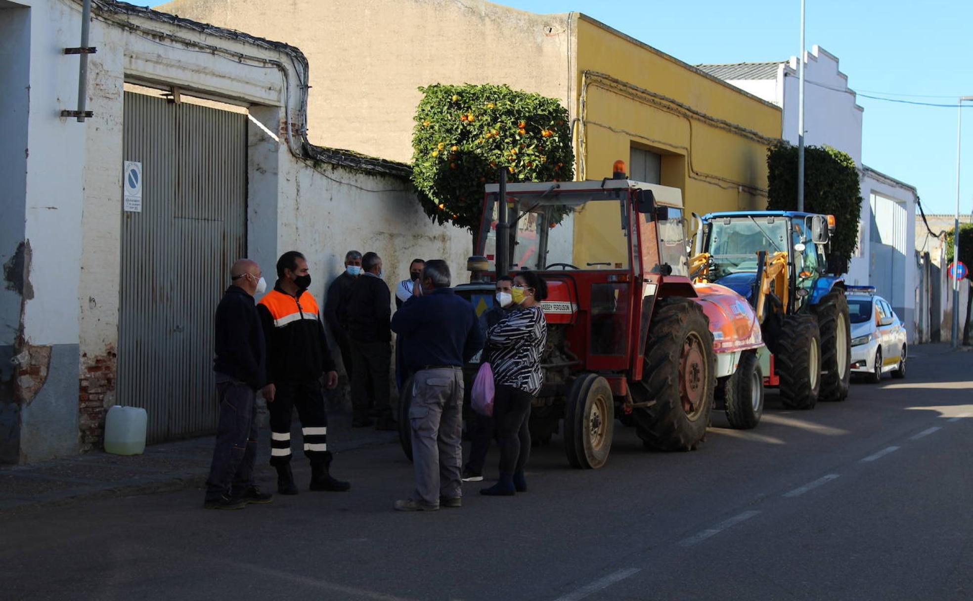 Algunos voluntarios esperan frente a la cochera en la que se reúnen todos los tractores
