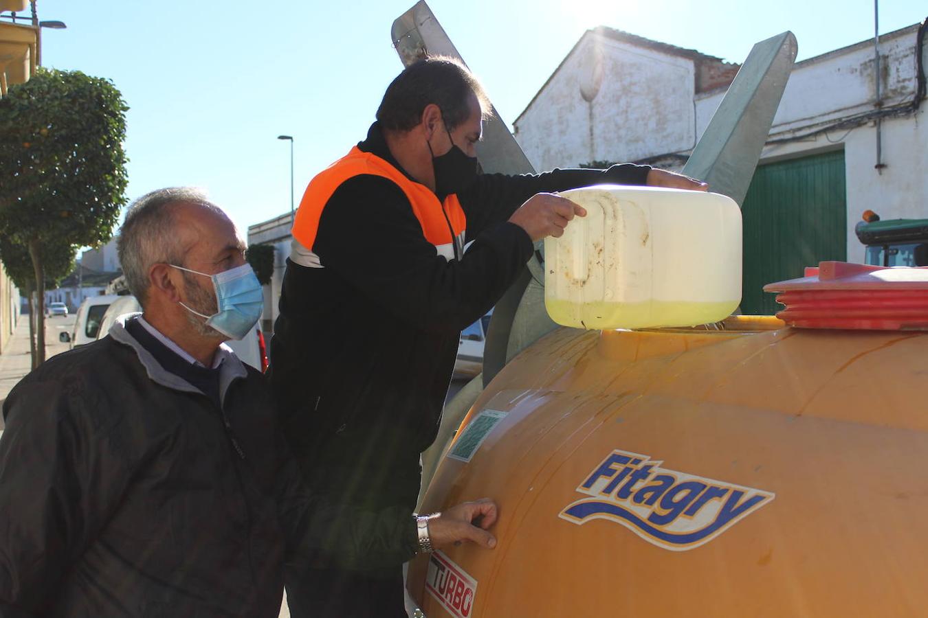 Miembros de Protección Civil ayudan a echar los productos en los atomizadores de los tractores 