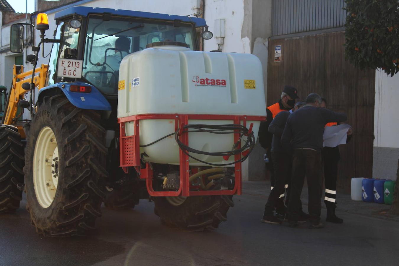 Andrés García, concejal de Sanidad, repasa los últimos detalles junto a miembros de Protección Civil al lado de un tractor sin atomizador, pero con un bidón del que salen las pistolas que utilizarán los voluntarios que fumigan a pie