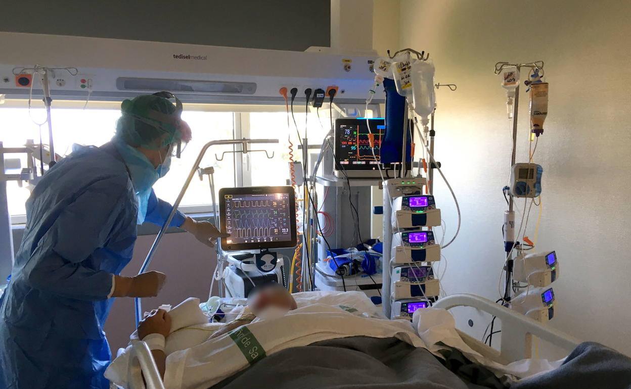 Imagen de archivo de un médico atendiendo a un paciente con covid en la UCI del Universitario de Cáceres. 