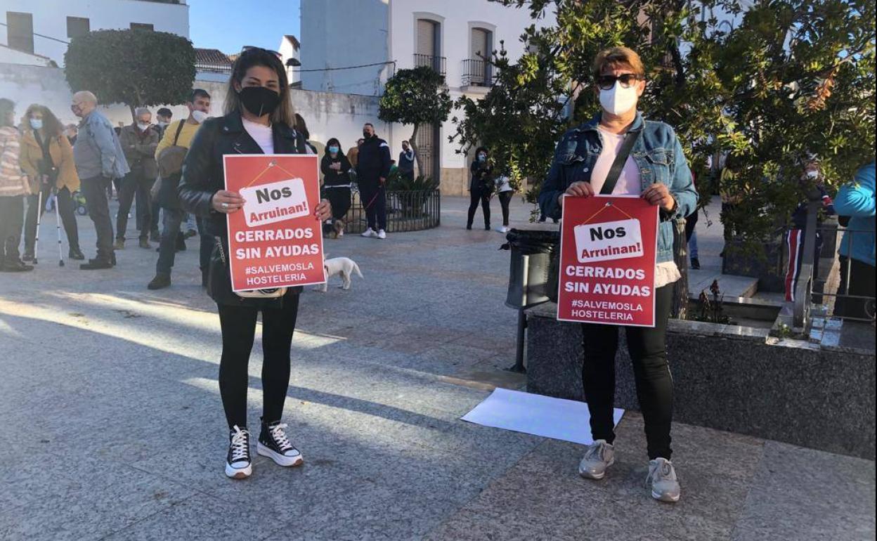 Dos asistentes a la concentración sujetan carteles de protesta
