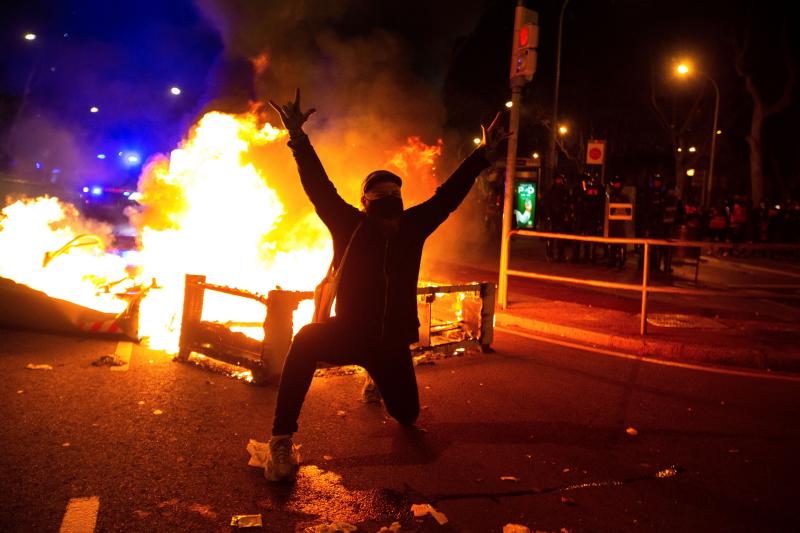 Un manifestante provoca a la Policía delante de una barricada en llamas.