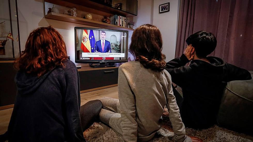 Miembros de una familia siguen el discurso extraordinario de Felipe VI del 18 de marzo. 