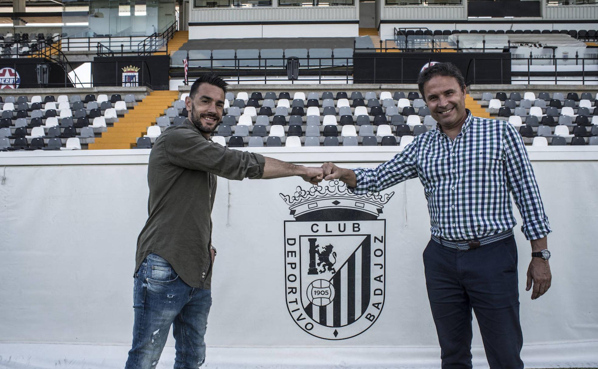 Guzmán y Rodri, los dos grandes capitanes históricos del Badajoz, se saludan delante del escudo del club en el Nuevo Vivero. 