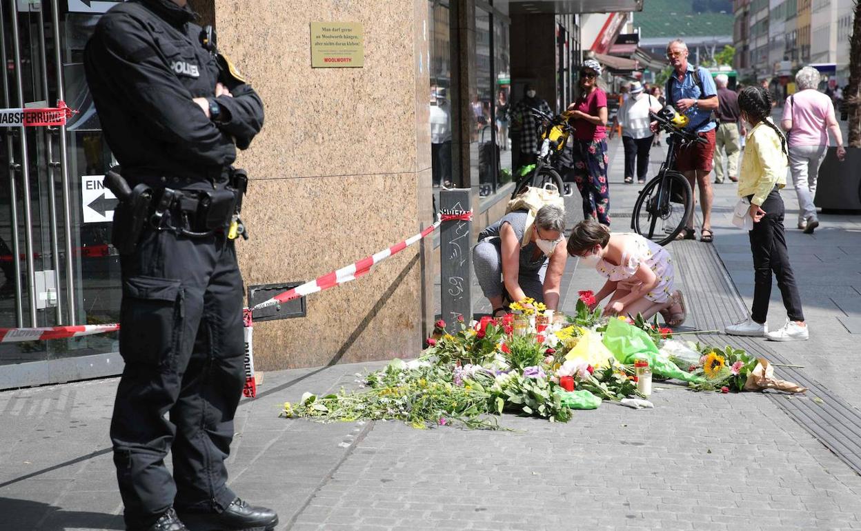 Dos personas dejan flores en la calle de Wurzburgo donde el viernes fue atacada una de las mujeres asesinadas.