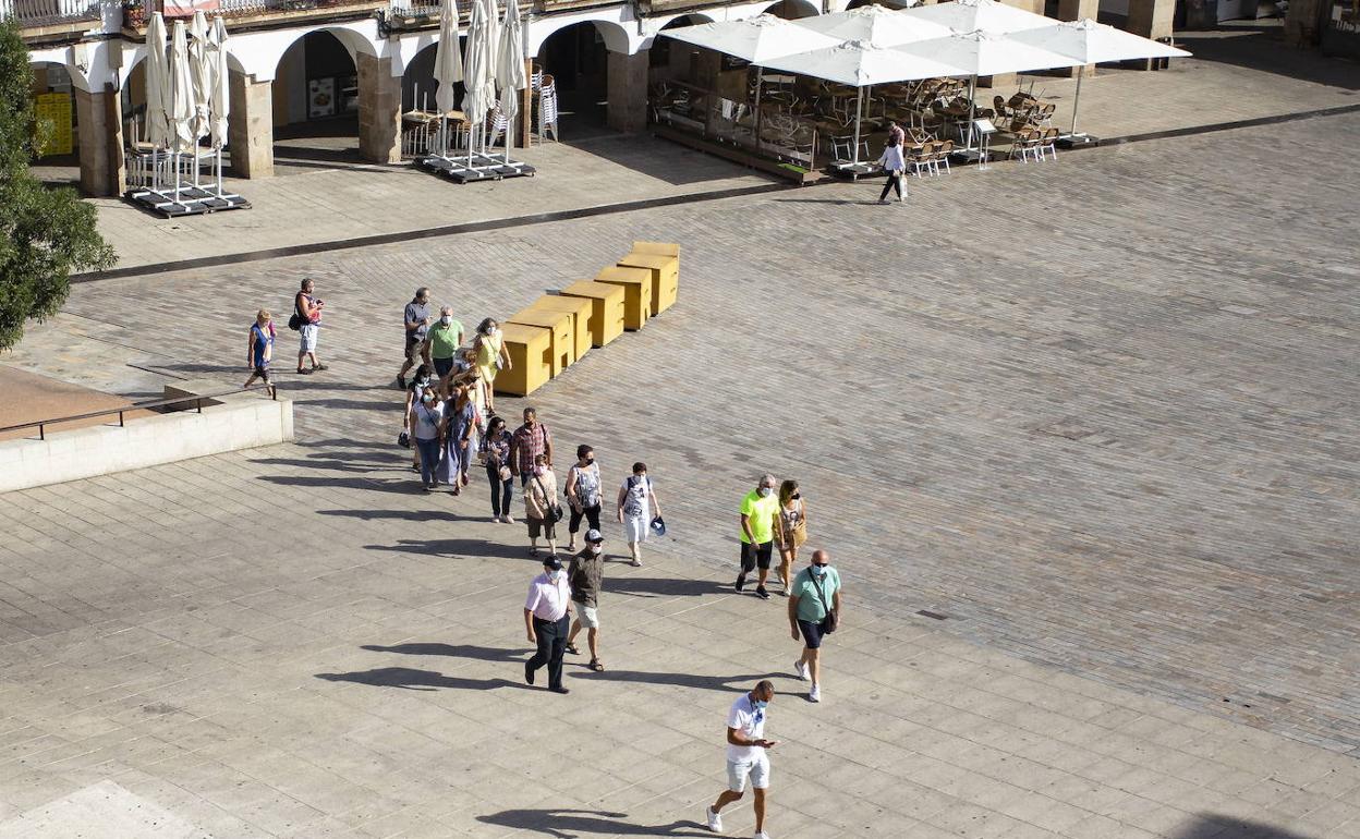 Turistas en la Plaza Mayor, junto a las letras tridimensionales de Cáceres. 