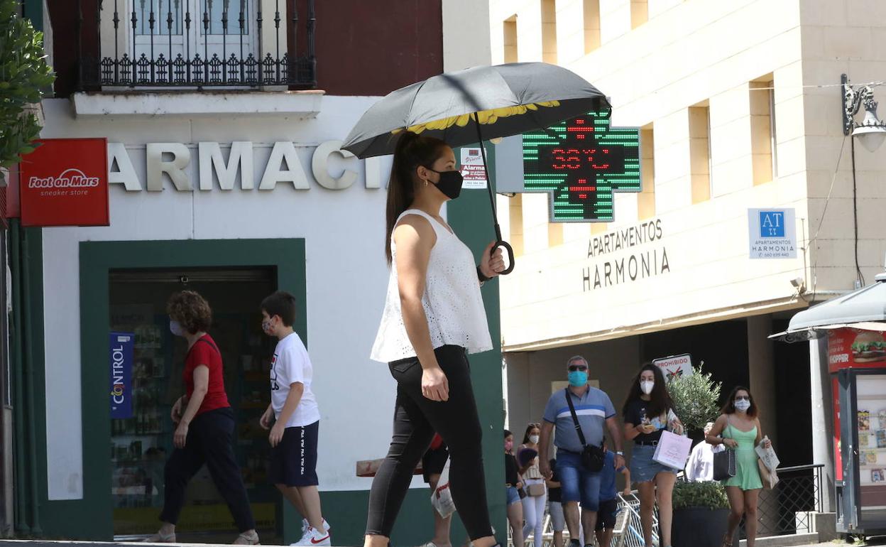 El calor de estos días (en la imagen, una mujer se protege con un paraguas en Mérida) y la entrada de aire frío favorecen las tormentas. 