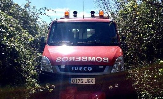 Un coche de los bomberos trata de abrirse paso entre la maleza. 