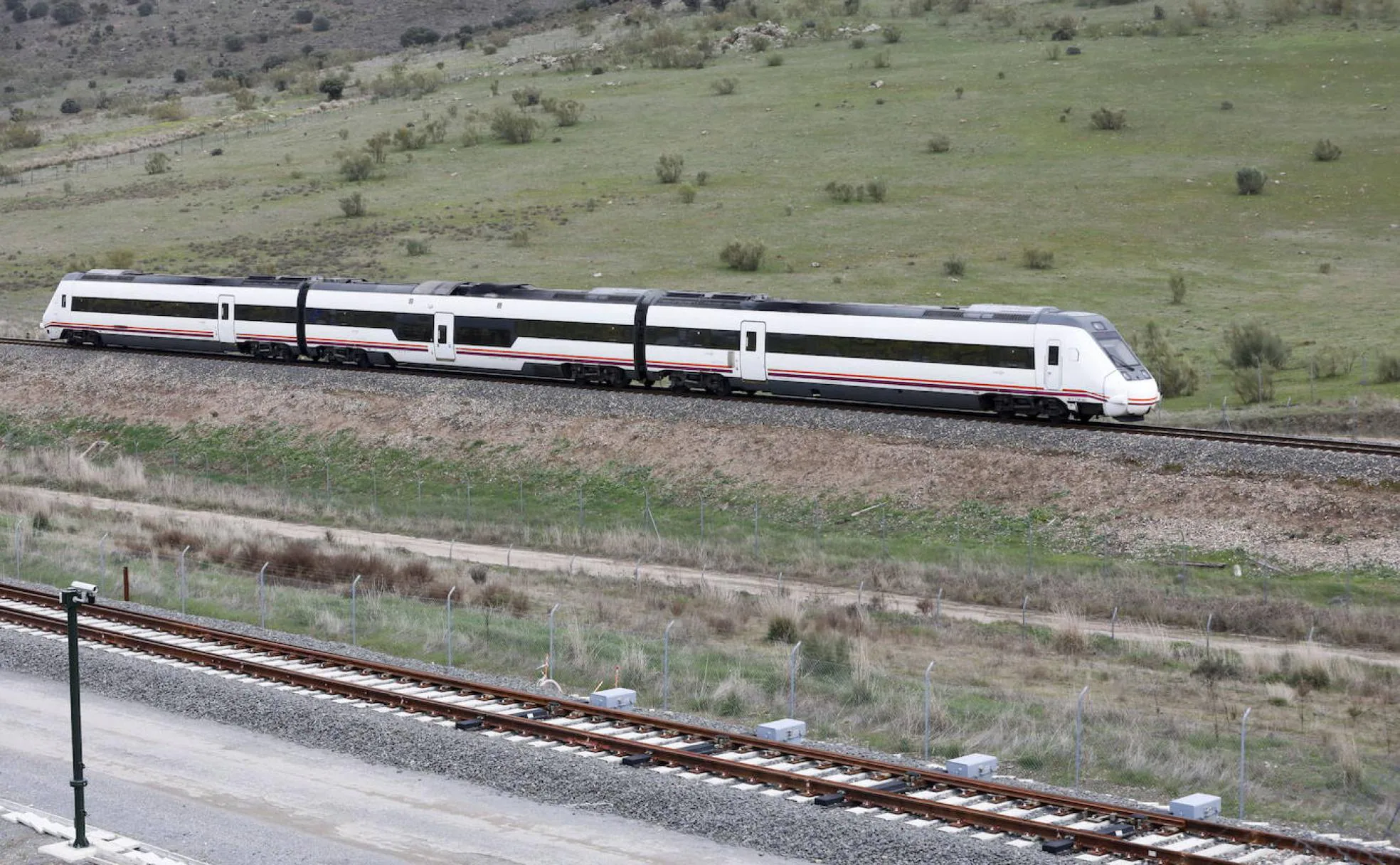 Un tren convencional pasa junto a la vía del AVE en las cercanías de Cáceres. 