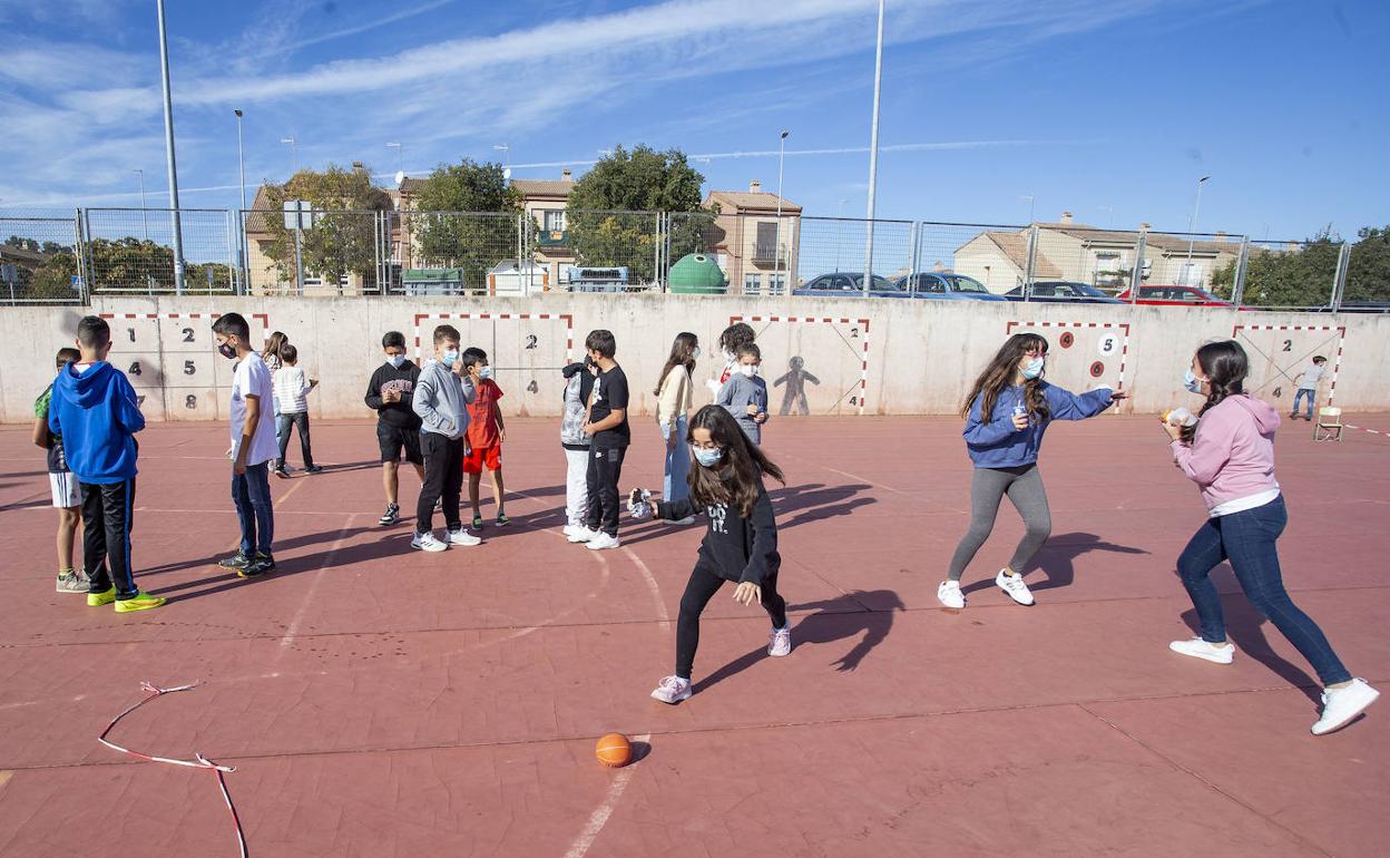 Alumnos del colegio Castra Caecilia de Cáceres con mascarilla jugando en el recreo este lunes.