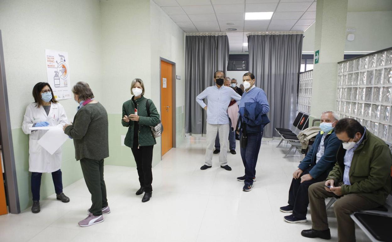 Usuarios del centro de salud La Mejostilla, de Cáceres, haciendo cola para vacunarse de la tercera dosis de la covid y en algunos casos de la gripe. 
