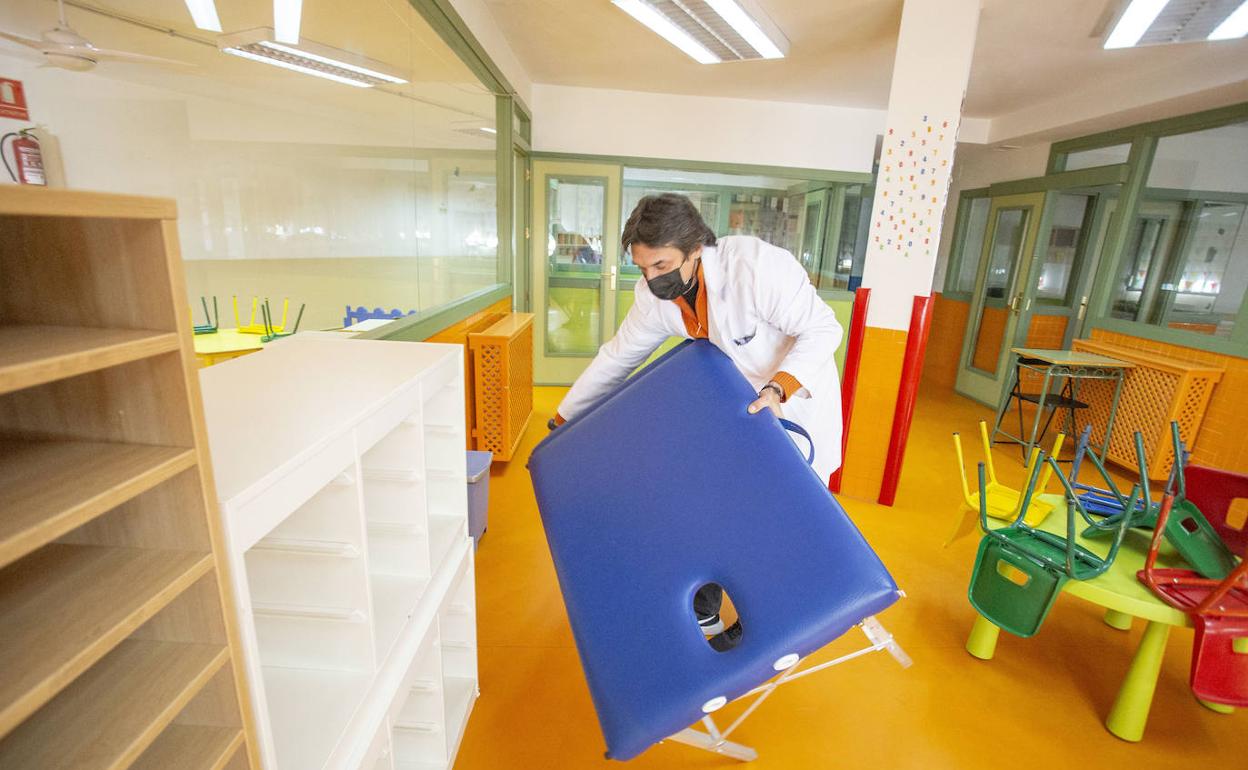 El director del Paideuterion habilitando una sala para la vacunación.