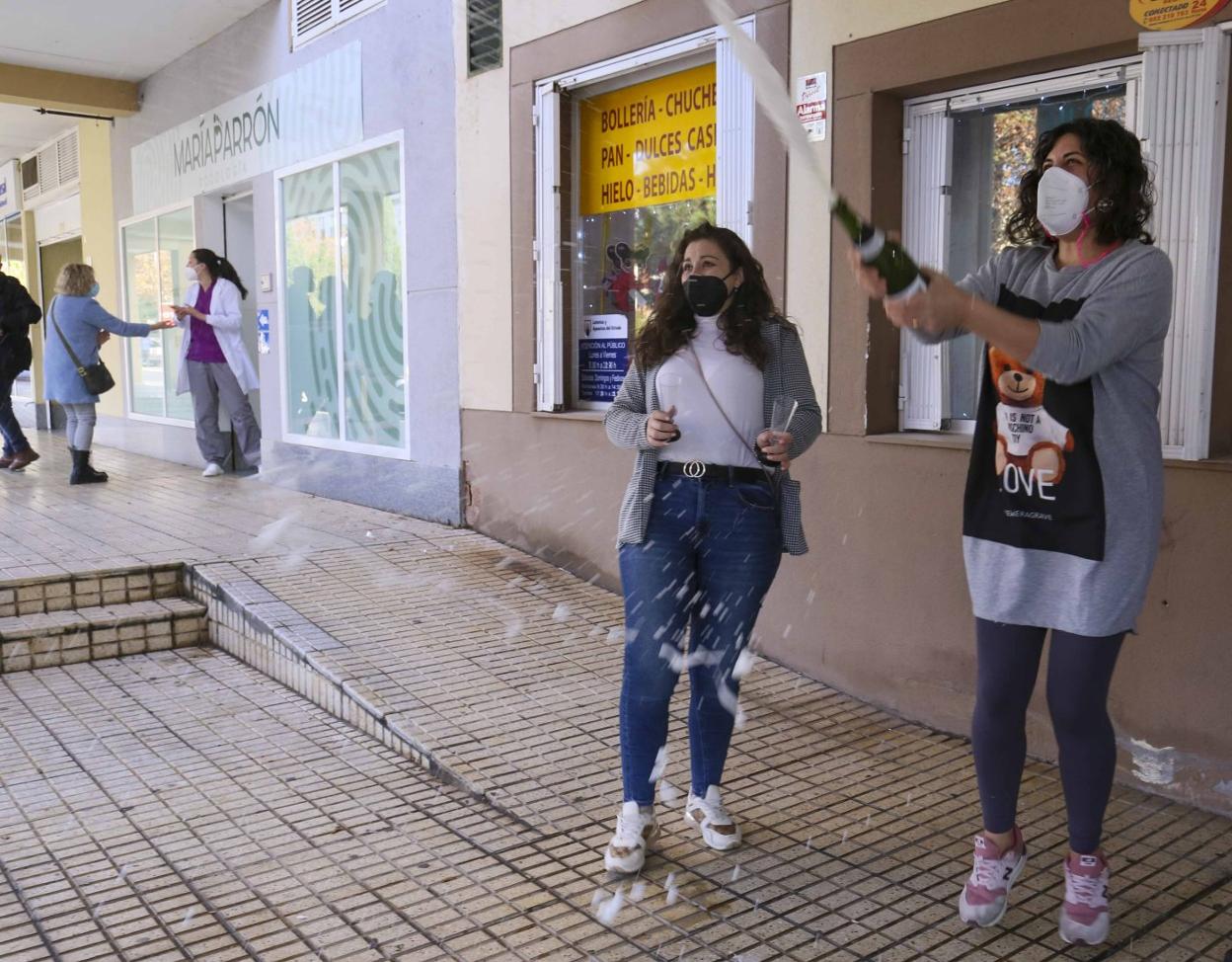 Yanet Solís descorchando la botella de cava extremeño delante de su tienda. 