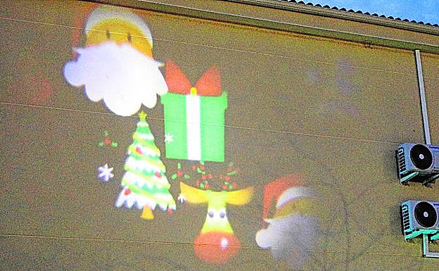 Motivos navideños proyectados sobre una casa del barrio. 