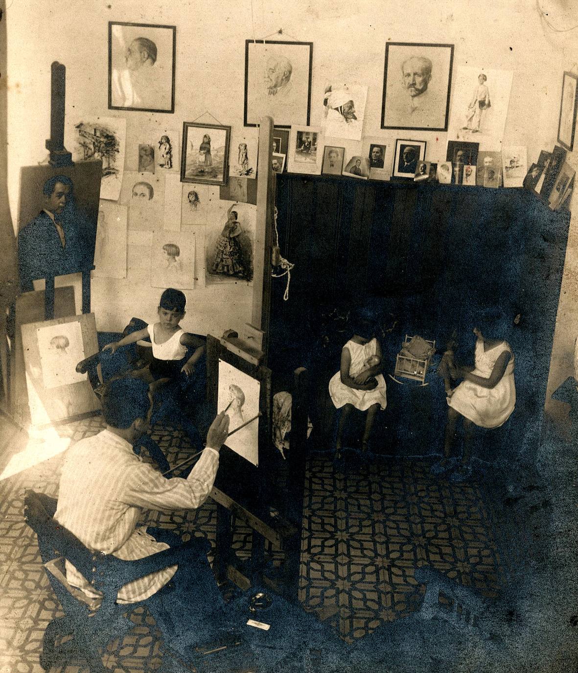 El pintor Solís Ávila en su estudio de Madrid con sus tres hijos. Está pintando a Antonio, mientras Carmen y María Teresa juegan a las muñecas