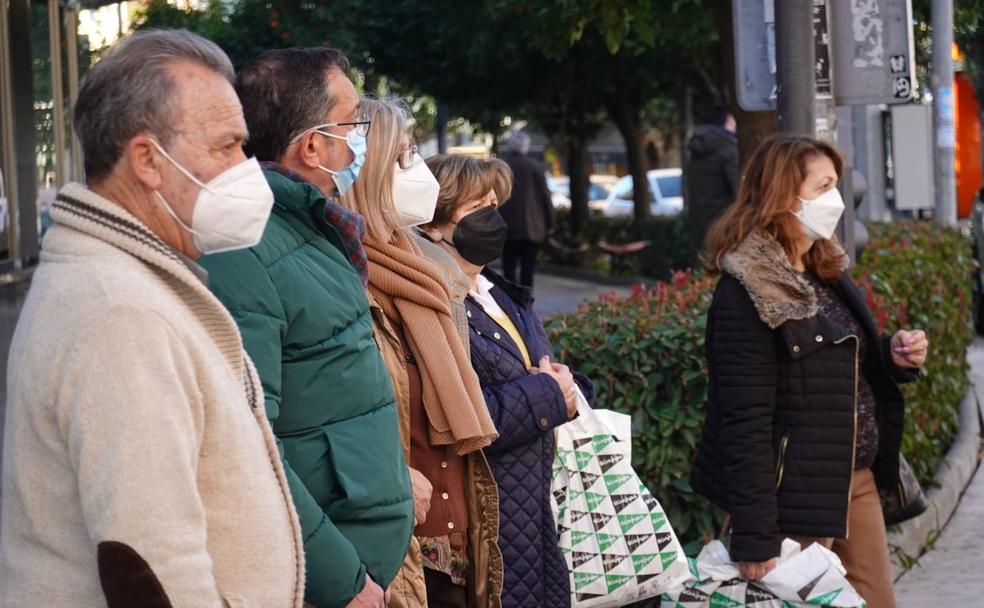 Vecinos con mascarilla este lunes en una calle de Badajoz. 