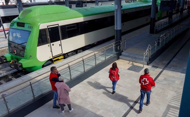 Voluntarios de Cruz Roja acompañando a los refugiados en el andén de la estación de Badajoz. 